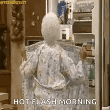 an elderly woman in a robe is standing in front of a refrigerator .