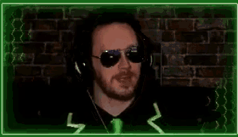 a man with a beard wearing sunglasses and headphones .