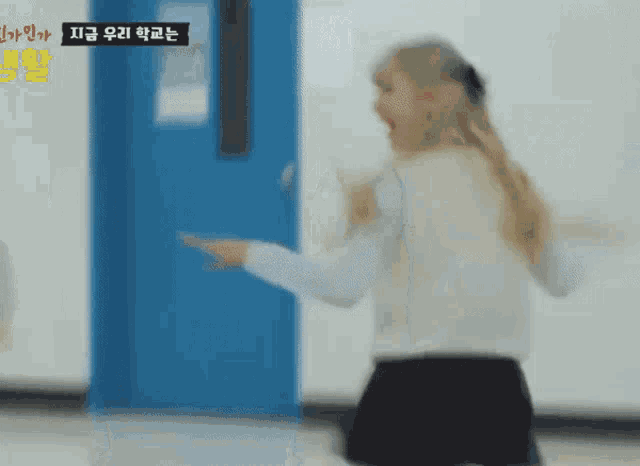 a blurry picture of a girl screaming in front of a blue door with chinese writing on it
