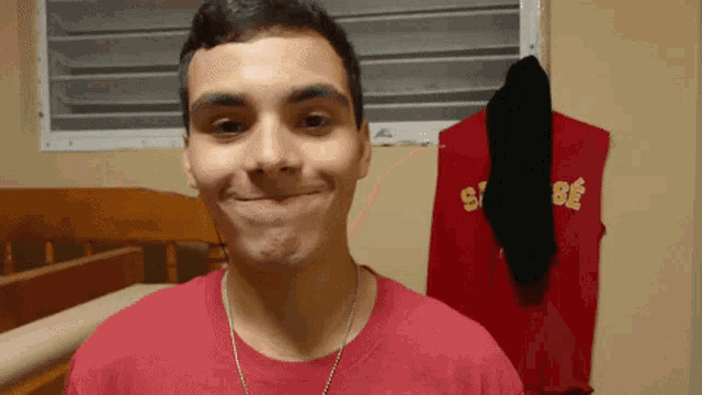 a young man wearing a red t-shirt with the letters s and b on it