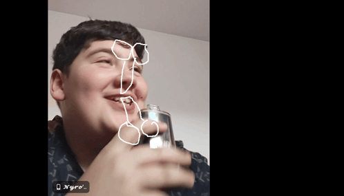 a boy holding a glass with a drawing of a penis on his face