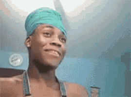 a man wearing a green bandana on his head is looking at the camera .