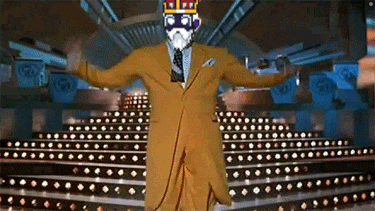 a man in a suit with a crown on his head is dancing on a stage