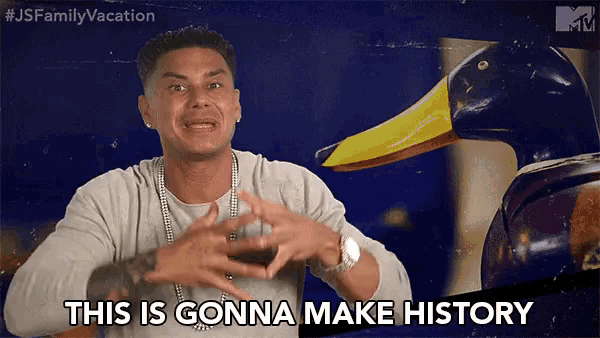 a man says this is gonna make history in front of a duck statue