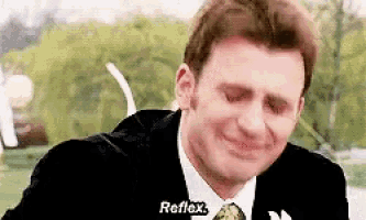 a man in a suit and tie is crying and saying `` reflex '' .