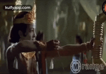 a man in a crown is holding a bow and arrow in a movie .