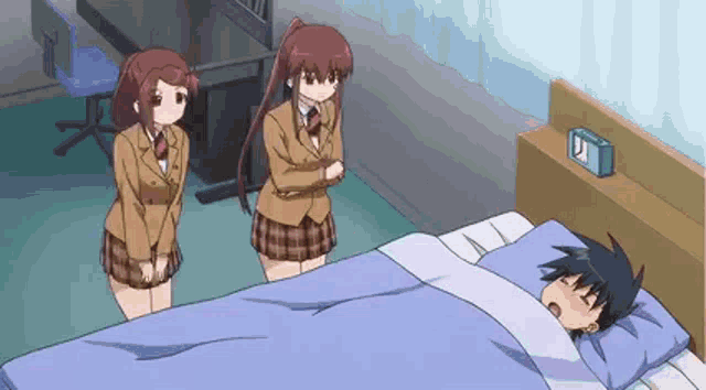 a man is sleeping in a bed with two girls standing around him