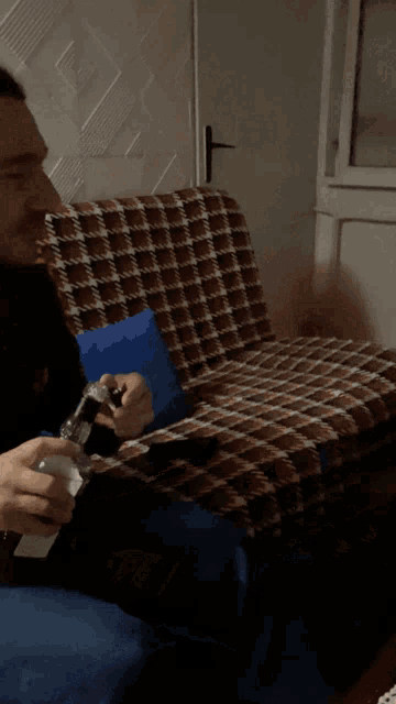 a man sitting on a couch holding a bottle of alcohol