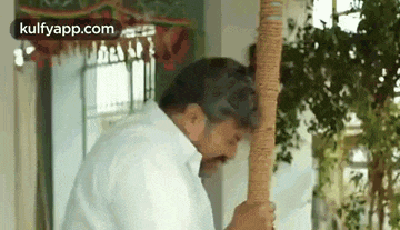a man in a white shirt is holding a rope in his hands .