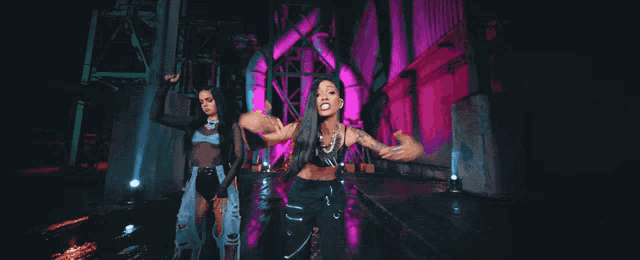 a woman with a tattoo on her arm is dancing with another woman