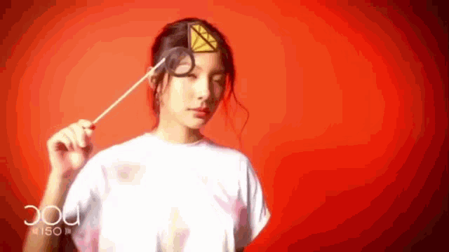 a woman in a white shirt is holding a stick with a diamond in her hair .