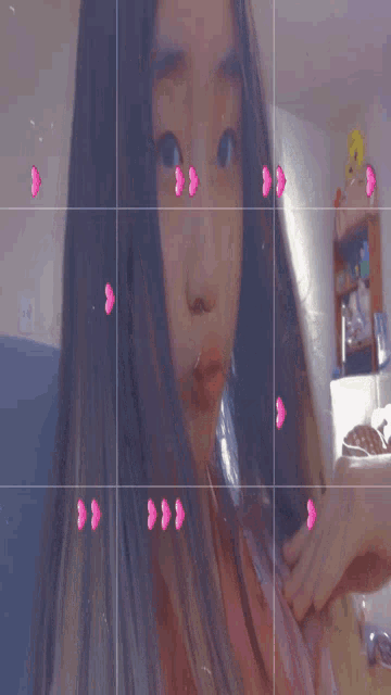 a girl taking a selfie with pink hearts around her face
