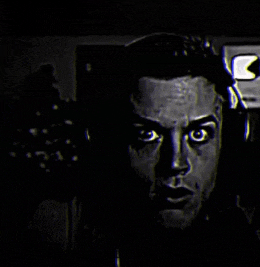 a black and white photo of a man 's face with the letter k in the corner
