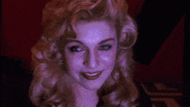 a close up of a woman 's face with blue lights behind her