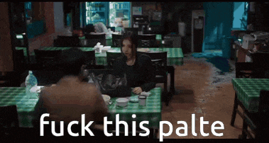 a man and a woman are sitting at a table in a restaurant with the words fuck this palte on the bottom