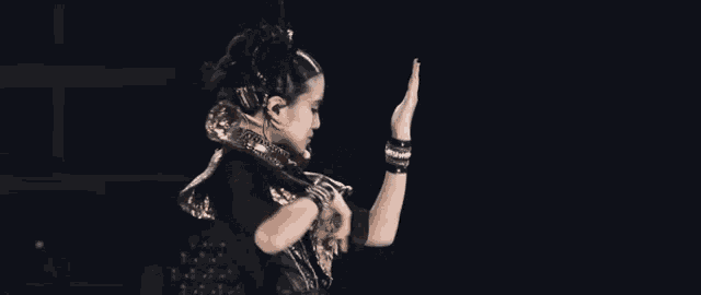 a woman is making a funny face while holding a microphone in her hand .