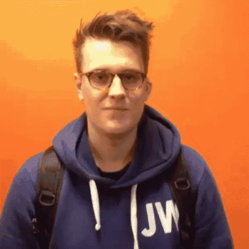 a man wearing glasses and a blue hoodie with jw on it