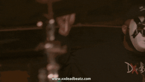 a blurred image with the website www.xxxdeadbeatz.com visible