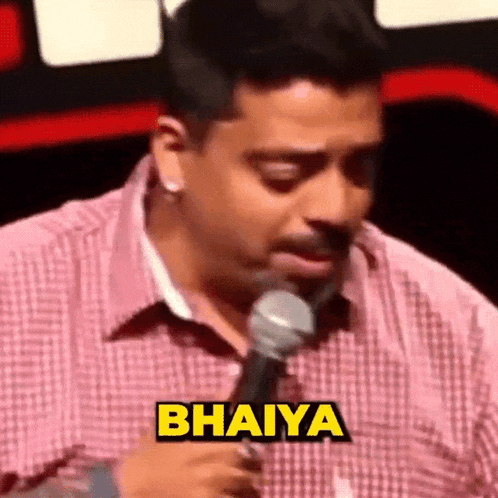 a man in a plaid shirt is holding a microphone with the word bahiya on it .
