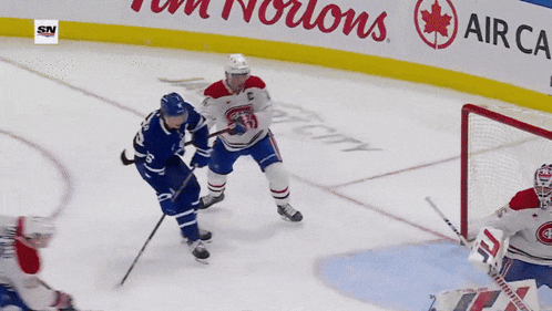 a hockey game is being played in front of a sign that says tim hortons