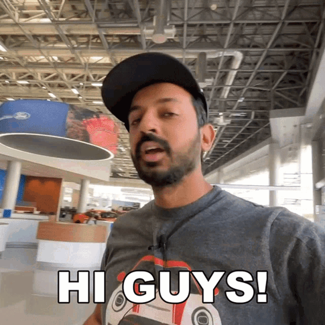 a man wearing a hat and a t-shirt that says hi guys
