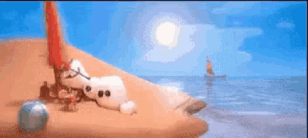 a snowman is laying on a sandy beach next to the ocean