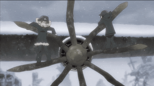 a couple of people standing on a plane propeller in the snow