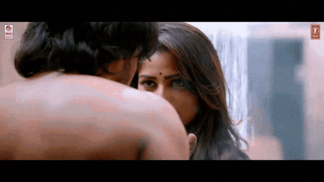 a man without a shirt kisses a woman on the forehead in a scene from a movie