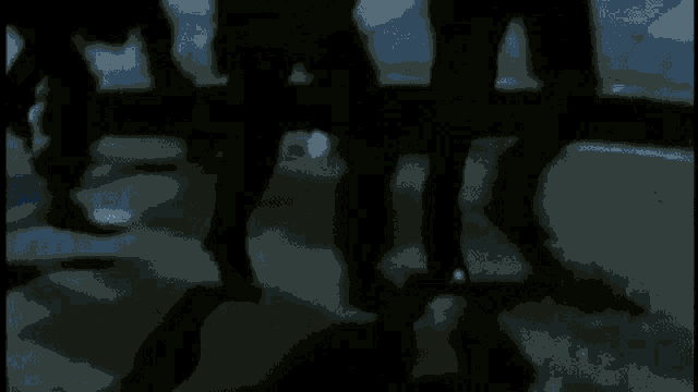 a group of people walking in the dark with their shadows on the ground