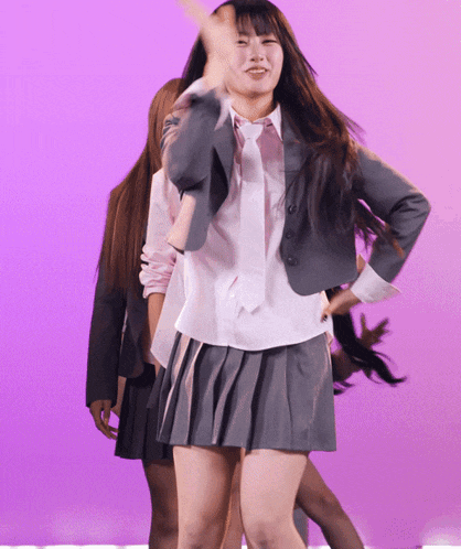 a woman in a school uniform is dancing on a stage
