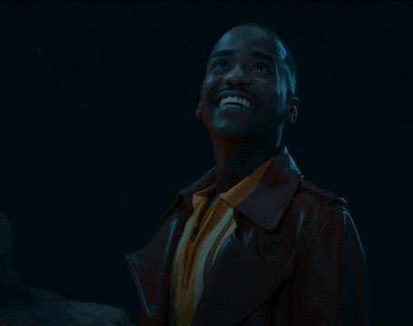 a man wearing a red jacket and a yellow shirt is giving a peace sign