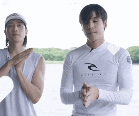 a man wearing a white ripcurl shirt is clapping his hands