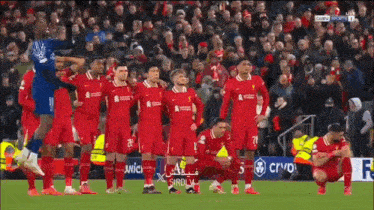 a group of soccer players are kneeling down on a field