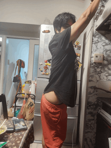 a man is standing in front of a fridge with a bag of rice on it