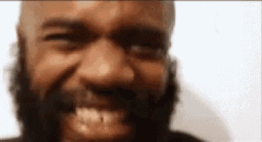 a close up of a man with a beard smiling with his mouth open .