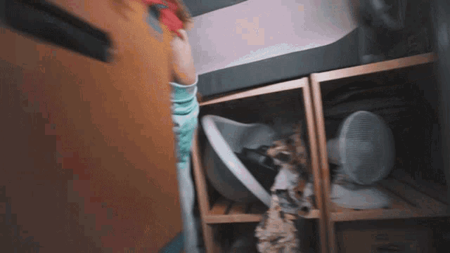 a person standing in a closet with a fan