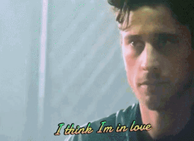 a close up of a man 's face with the words i think i 'm in love above him