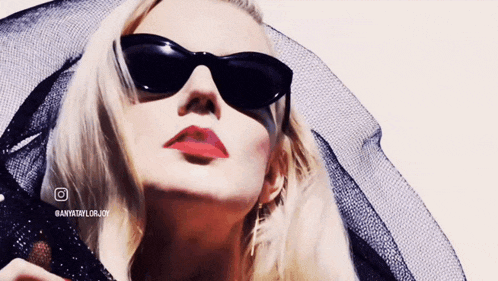 a close up of a woman wearing sunglasses and a black veil with the hashtag @anyxtaylorjoy