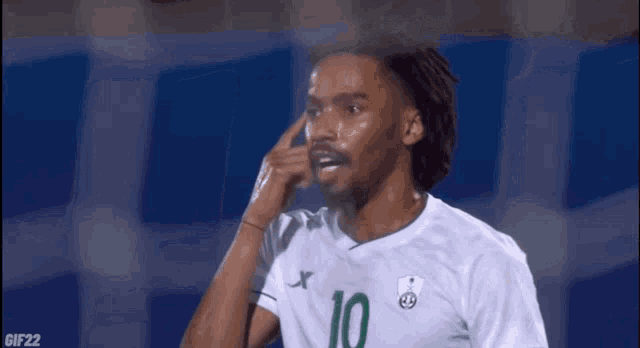 a soccer player wearing a green and white jersey with the number 10 on it .