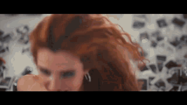 a close up of a woman 's face with red hair