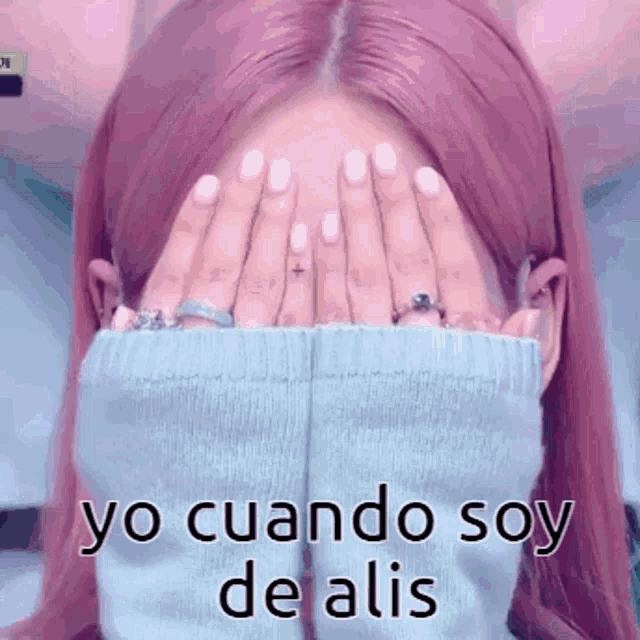 a woman with pink hair is covering her face with her hands with the words yo cuando soy de alis written below her
