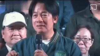 a man is holding a microphone and crying in front of a crowd .