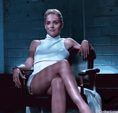 a woman is sitting in a chair with her legs crossed and her hands on her knees .