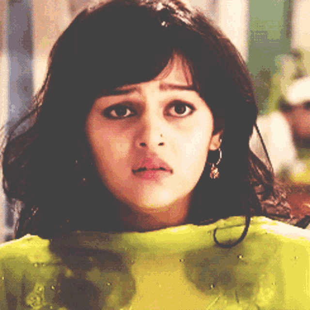 a close up of a woman 's face with a yellow top