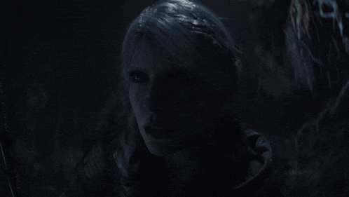 a close up of a woman 's face with a dark background