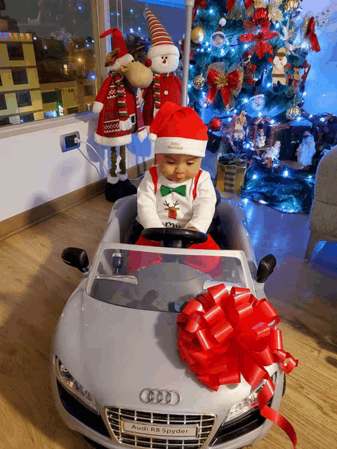 a baby is sitting in an audi r8 spyder toy car
