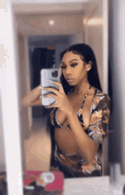 a woman is taking a selfie in the mirror .
