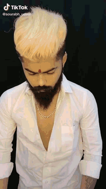 a man with blonde hair and a beard wearing a white shirt
