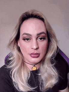 a woman with blonde hair is wearing a choker and a black shirt .