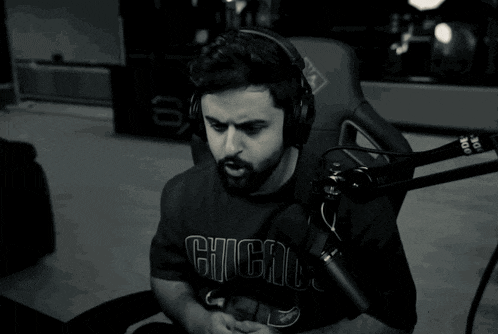 a man wearing headphones is singing into a microphone and his shirt says ig